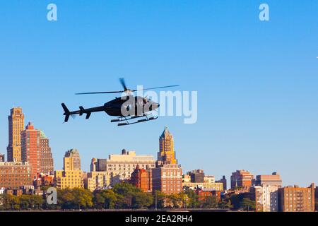 Helicopter is under Brooklyn. Black helicopter flies against the background of Brooklyn in the city of New York, USA. NEW YORK CITY - USA: OCTOBER 15 Stock Photo