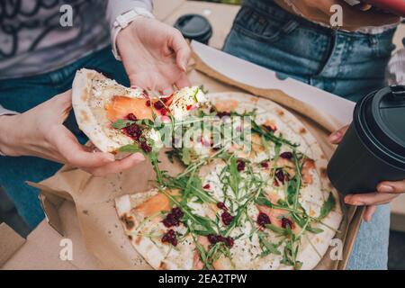 Delicious fresh and flavorful Italian pizza with salmon, arugula greens and spicy cranberry sauce. Quick and satisfying snack and lunch Stock Photo