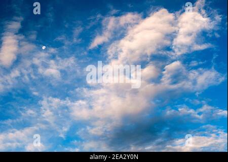 Cirrus Clouds with moon in morning light Stock Photo