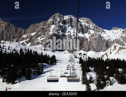 Ski Area Ehrwalder Alm With View To Mount Zugpitze Austria During A Chairlift Ride On A Beautiful Sunny Winter Day With  a Clear Blue Sky Stock Photo