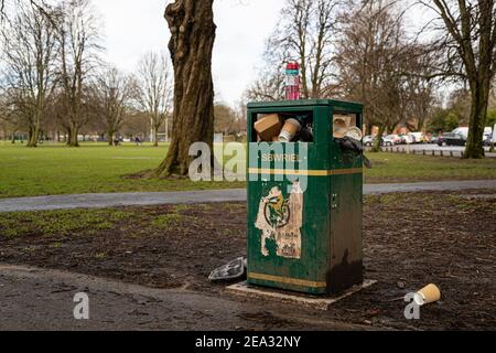 Cardiff, Wales - February 3rd 2021: A litter bin overflows with rubbish at  Llandaff Fields, Cardiff Stock Photo