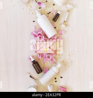 Romantic festive still life with cosmetics bottles, accessories, a gift box and rose petals on white background. Valentine's Day. Festive bath time fo Stock Photo