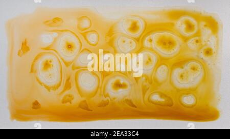 Abstract yellow paint background. Paint stains and splashes. Fluid art. Stock Photo