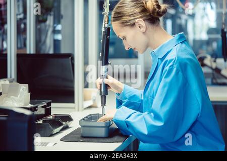 Woman in factory assembling a product Stock Photo