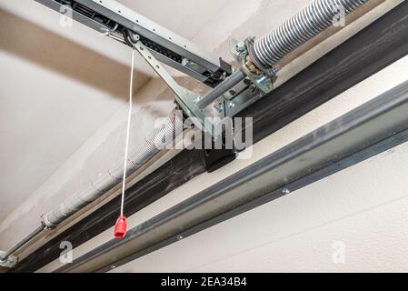 Springs tensioning the home garage door mechanism, view from the inside, visible rail with chain. Stock Photo