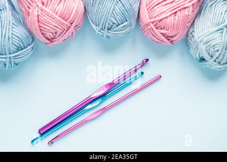 knitting pink crochet hooks and woolen thread on a blue background Stock  Photo - Alamy