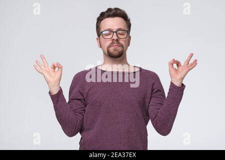 Caucasian funny man meditating on yoga class. Studio shot Stock Photo