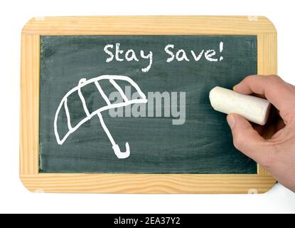 Stay save written on a chalkboard with an umbrella drawing Stock Photo