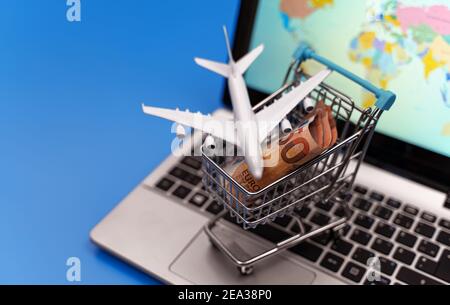 Shopping cart with plane toy. Air tickets sale concept. Stock Photo