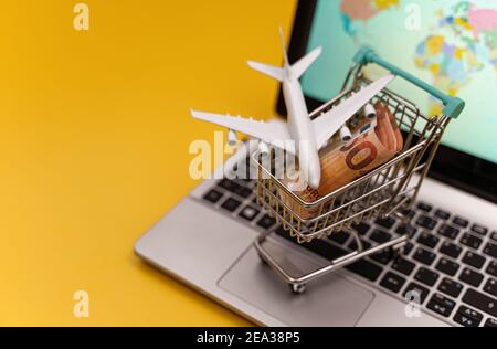 Shopping cart with plane toy. Air tickets sale concept. Stock Photo