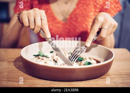 Happy Asian woman enthusiastically eats a delicious dish in a Haute cuisine restaurant. Stock Photo