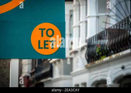 Estate agent 'to let' sign on street of houses Stock Photo