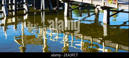 Whimsical reflections of a bridge railing in the water of a canal in the city of Leiden, Holland Stock Photo