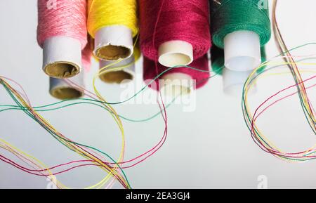 Multicolored threads in the coils are reflected on the surface of the mirror. Sewing and needlework. High quality photo Stock Photo