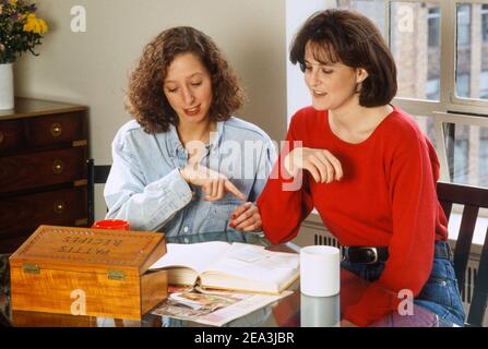 Two young women compare cooking recipes, USA Stock Photo