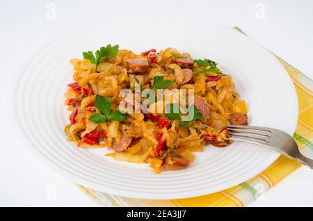 Stewed vegetables, cabbage, paprika with sausages. Studio Photo Stock Photo