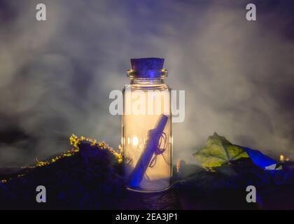 Image of a message in a stopper bottle and smoke backlit by warm light Stock Photo