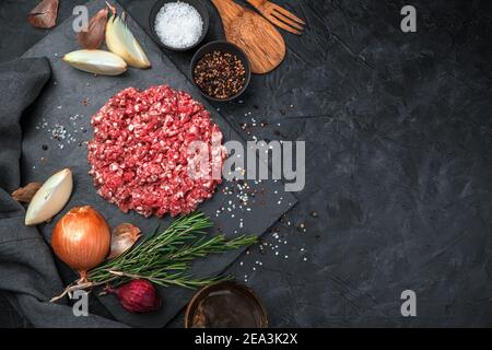 Culinary background with minced meat on black concrete. Top view, horizontal. Stock Photo