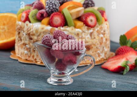 Fruit Cake with strawberries, raspberries and blueberries. Fruitcake with oranges, bananas and apples. Gift cake, birthday cake. Stock Photo