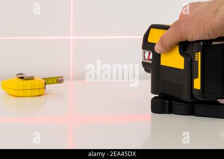 The fitter uses an electronic laser to measure angles and straight lines Stock Photo