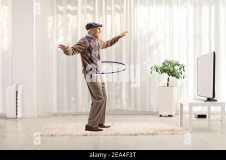 Cheerful man having fun and spinning a hula hoop isolated on white background Stock Photo