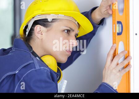 female builder using spirit level Stock Photo