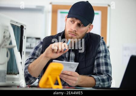 young energetic male tech or engineer repairs electronic equipment Stock Photo