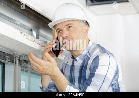construction worker having serious phone conversation Stock Photo