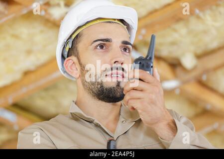 man on building site using walkie-talkie Stock Photo