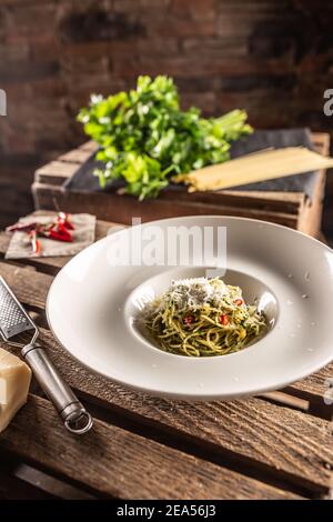 Spaghetti aglio e olio with olive oil, gralic, basil, parmesan cheese, tomatoes and chillies served in a deep plate. Stock Photo