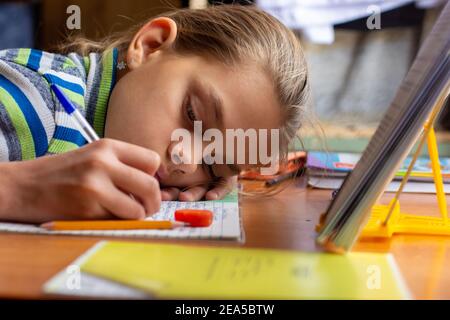 Girl from fatigue put her head on the table doing homework Stock Photo