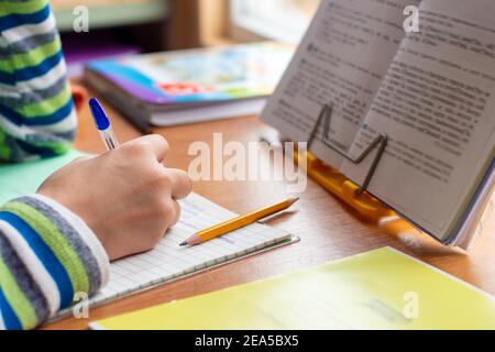 Close-up view of the hands of a schoolboy doing homework Stock Photo