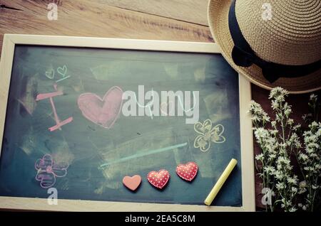 Blackboard with words written in shock that the 'I LOVE YOU' and a floral heart was placed next to the board - the concept of Valentine's Day. Stock Photo