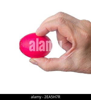 a broken red Easter egg in the hand of an elderly woman is isolated on a white background. Stock Photo
