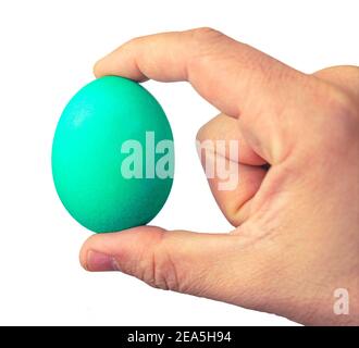 man holds green Easter egg in hand, close up isolated on a white background Stock Photo