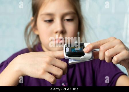 little girl used to measure pulse rate and oxygen level. Patient with pulse oximeter on finger for monitoring Stock Photo