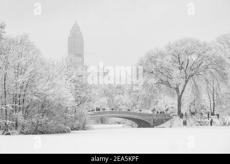 People standing along bridge in Central Park during a snowstorm. Stock Photo