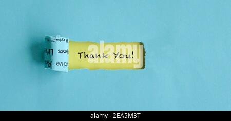 Torn blue paper with Thank You text on yellow background. Appreciation concept. Stock Photo