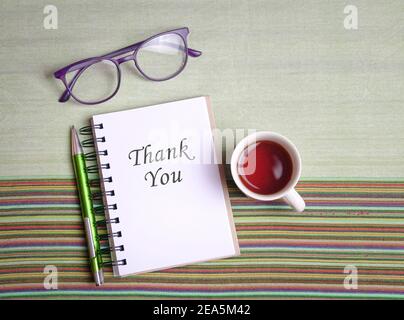 Thank you, words on notepad, with cup of coffee, pen and eyewear. Top view. Stock Photo