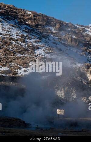 Hot Creek Geological Site is a famous landmark in Mono County. The hot springs, steam vents, curvy stream and mountain peaks create a beautiful scene. Stock Photo