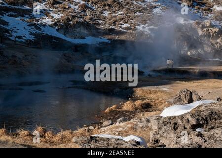 Hot Creek Geological Site is a famous landmark in Mono County. The hot springs, steam vents, curvy stream and mountain peaks create a beautiful scene. Stock Photo