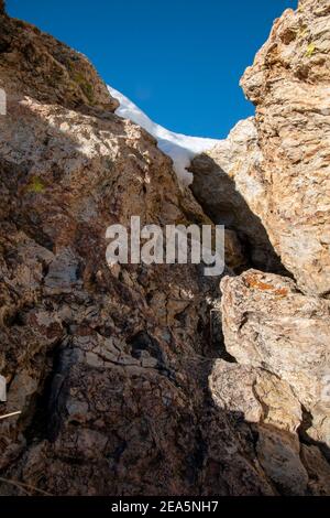 Hot Creek Geological Site is a famous landmark in Mono County. The hot springs, steam vents, curvy stream and mountain peaks create a beautiful scene. Stock Photo