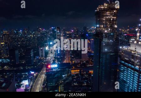 Close up aerial view of high rise skyscraper under construction in modern city center at night Tall skyscrapers in downtown Jakarta, Indonesia Stock Photo