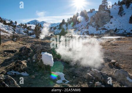 Hot Creek Geological Site is a famous landmark in Mono County. The hot springs, steam vents, curvy stream and mountain peaks create a beautiful scene. Stock Photo