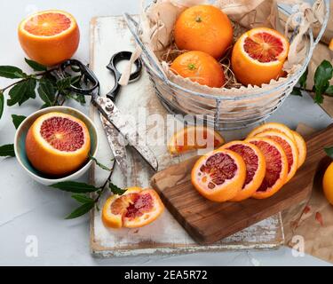 Oranges with leaves in basket, orange juice on light background. Top view Stock Photo