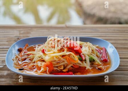 A plate of papaya salad, also known as &quot;Somtum&quot;, a traditional Thai cuisine with papaya, tomato, Chinese long bean, Thai chili pepper and dr Stock Photo