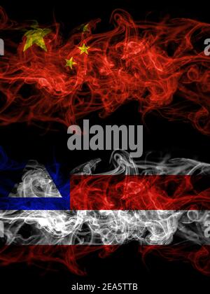 China, Chinese vs Bahia, Brazil smoky mystic flags placed side by side. Thick colored silky abstract smoke flags. Stock Photo