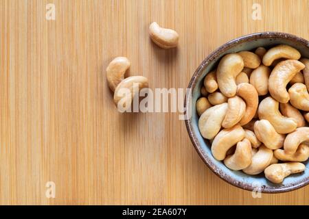 Сashew nuts in a bowl on a wooden background. Copy space. Healthy snack. Stock Photo