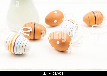 Easter eggs on wooden background. Striped and dotted easter eggs scattered on a table. Stock Photo