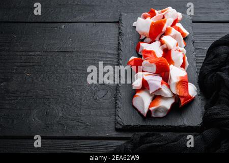 Crab sticks seafood semi finished fish mince with blue swimming crab set, on black wooden table background , with copyspace and space for text Stock Photo